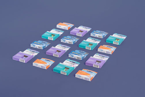 A rectangular array of 16 earplug packages including EarPlanes and WeatherX packages. Product is lying on a flat surface taken from a 45 degree angle.